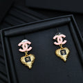 Gold-tone heart charm earrings with pink CC studs
