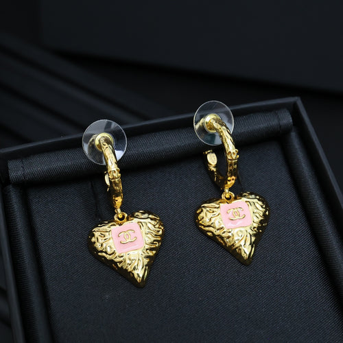 Gold-tone heart drop earrings with pink enamel logo, on hinged hoop hooks.