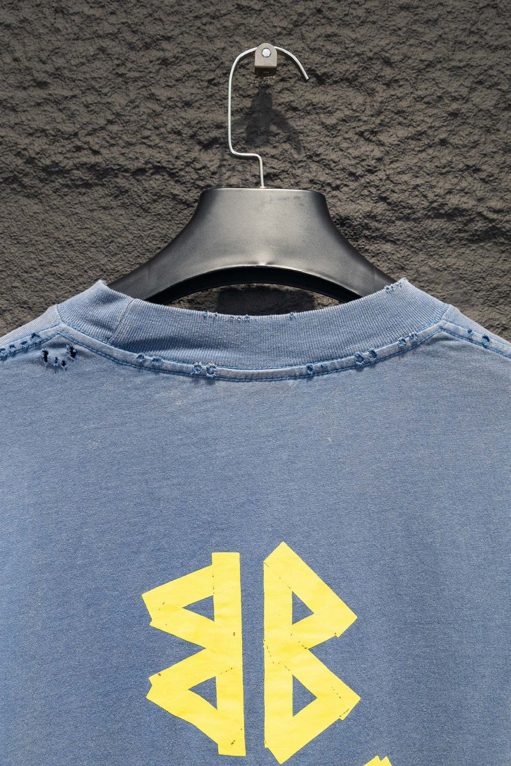 Light blue long-sleeve shirt back upper area with yellow logo graphic
