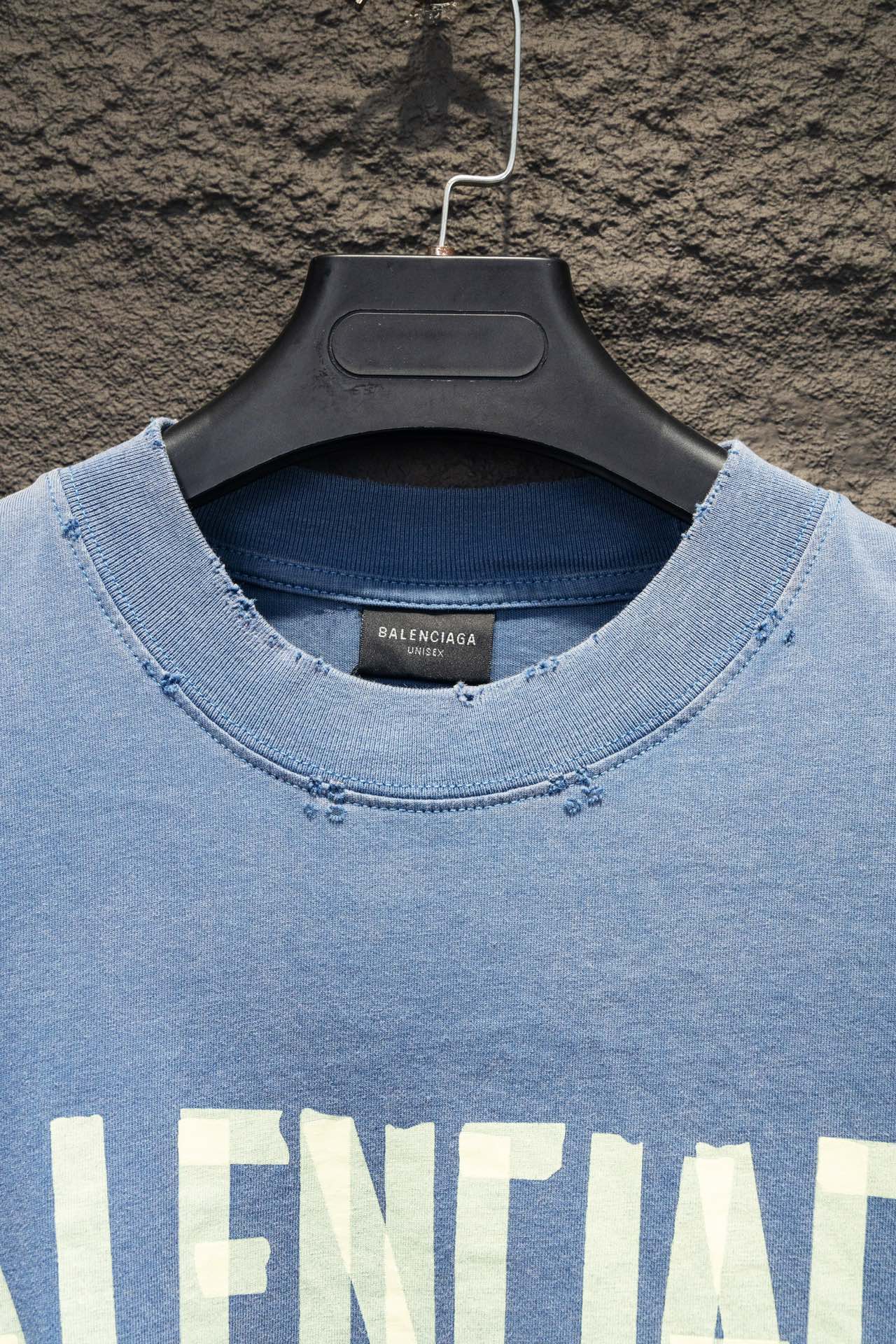Light blue long-sleeve shirt neckline with small logo embroidery detail