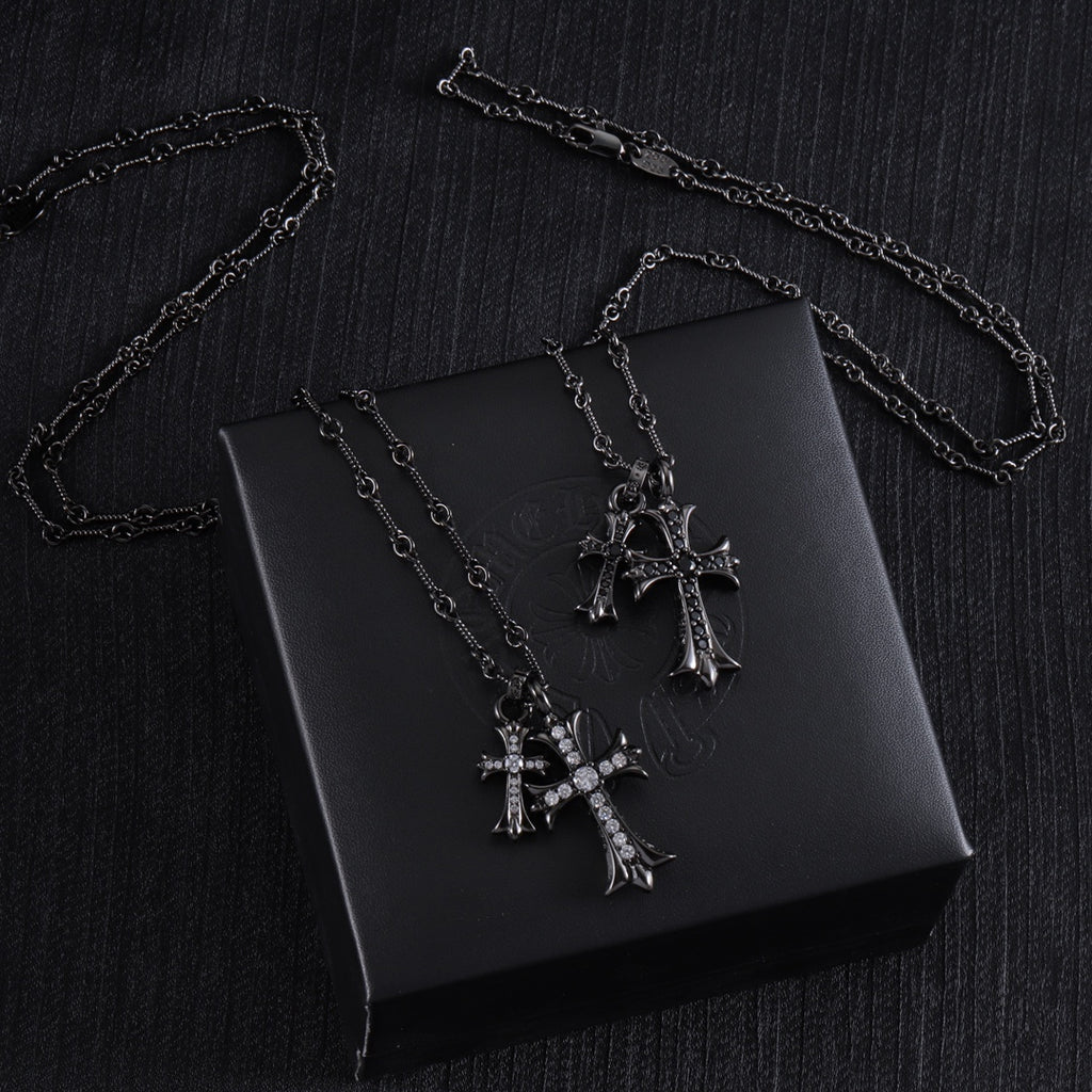 Cross pendant necklaces with silver-tone chains and clear-stone crosses on a black box
