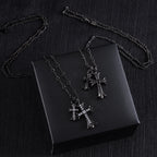 Cross pendant necklaces with silver-tone chains and clear-stone crosses on a black box