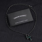 Chrome Hearts silver polishing cloth with silver-tone cross pendant necklace and green stones