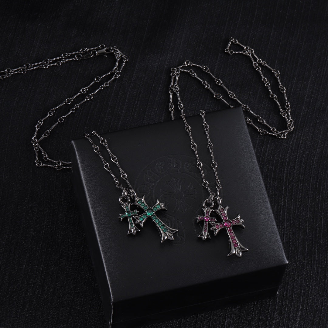 Cross pendant necklaces with silver-tone chains and colorful stone crosses on a black box