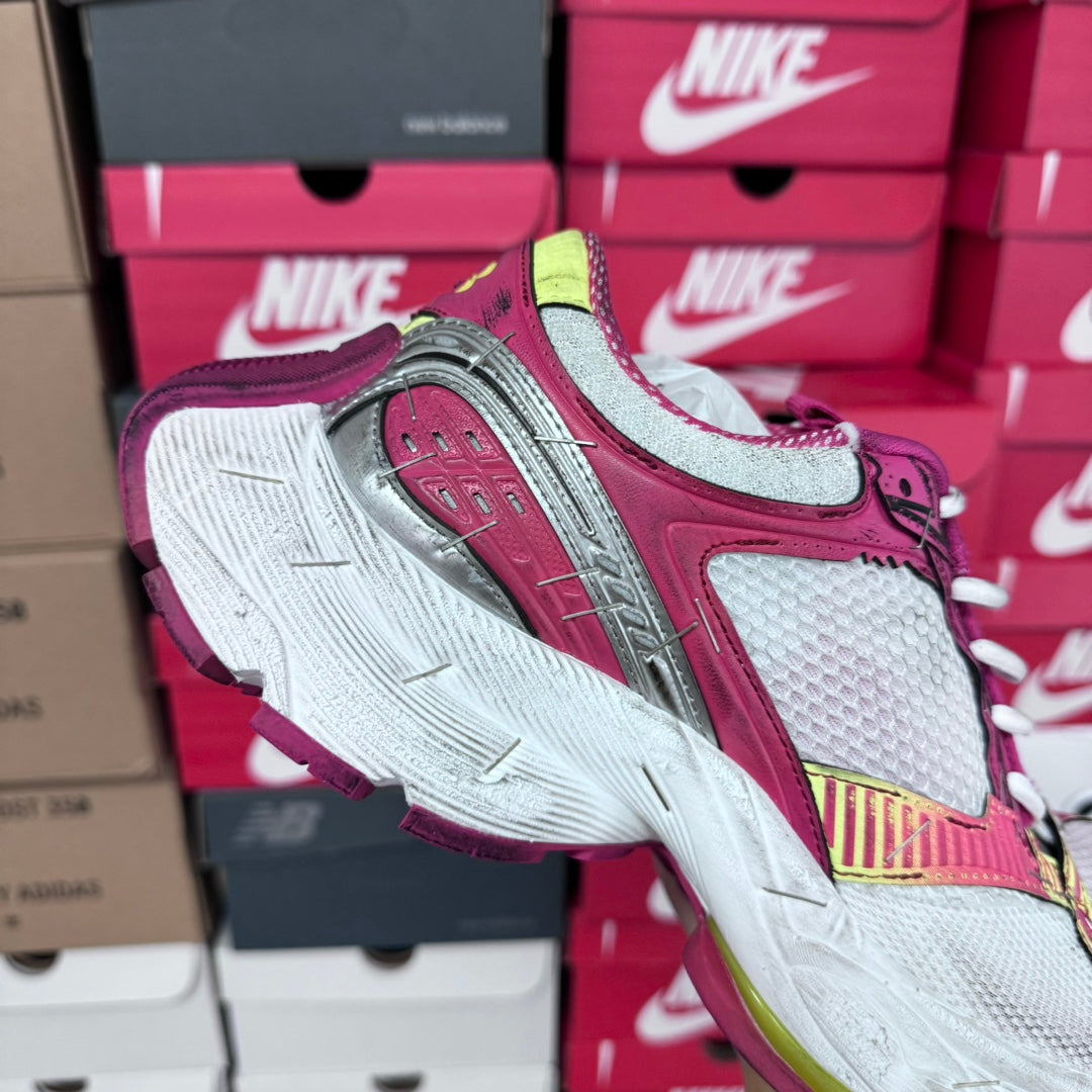 Diagonal side view of pink and gray sneakers with white laces and multicolor heel stripe