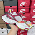 Pink, white, and gray lace-up sneakers with multicolor trim and thick white sole