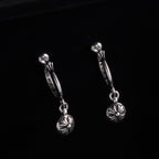 Silver drop hoop earrings with flower charm on a short linked chain