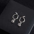 Silver hoop earrings with dangling flower charms and small crossbar detail