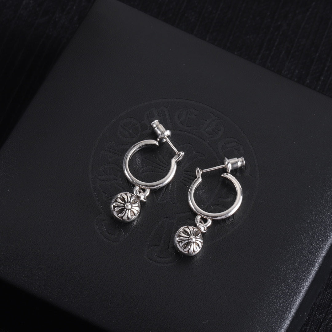 Silver hoop earrings with dangling flower charms and small crossbar detail