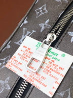 Louis Vuitton monogram zip with metal pull and hanging accessories tags
