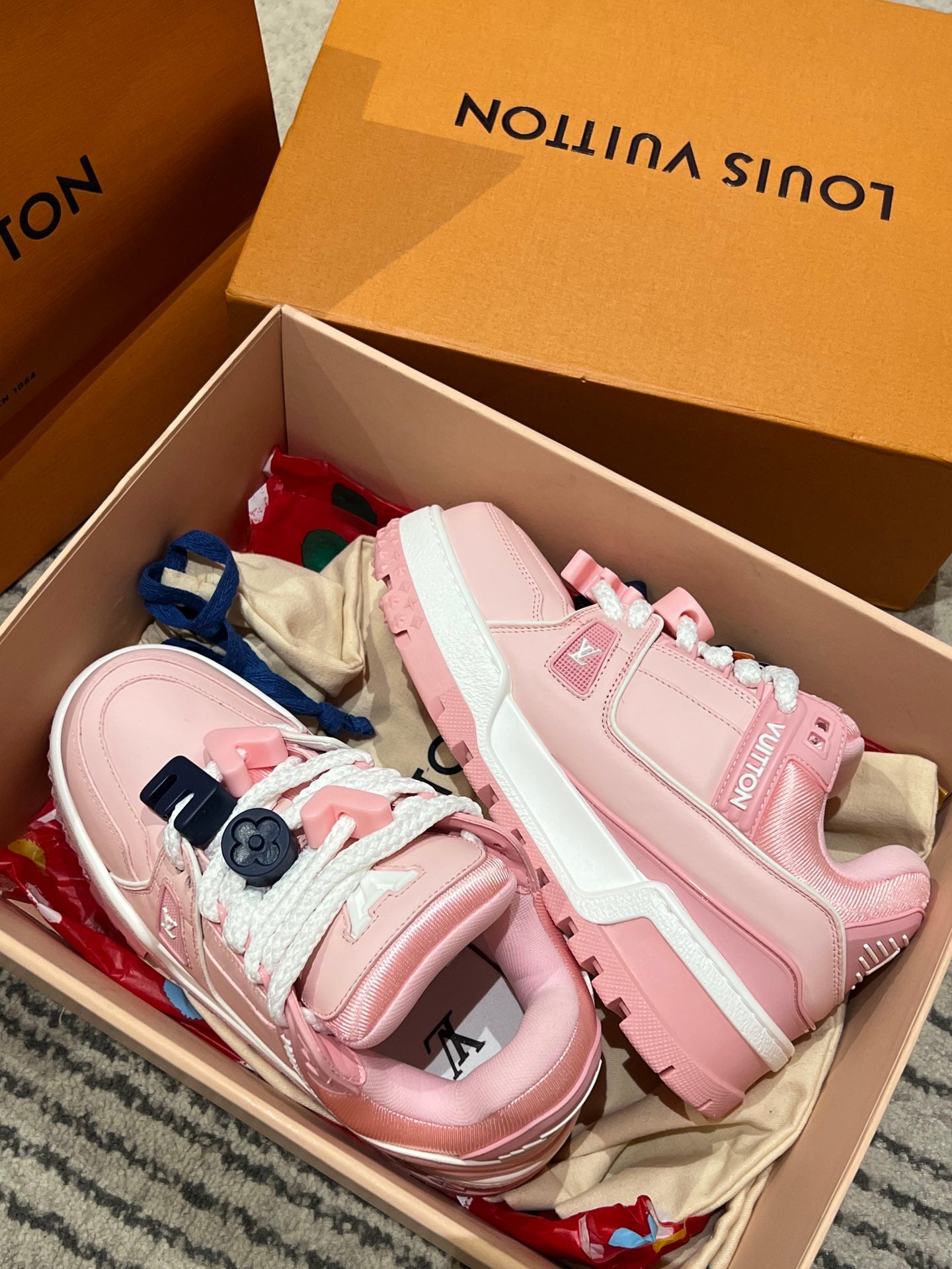 Pink and light-pink sneakers in a shoebox, with lace and decorative straps