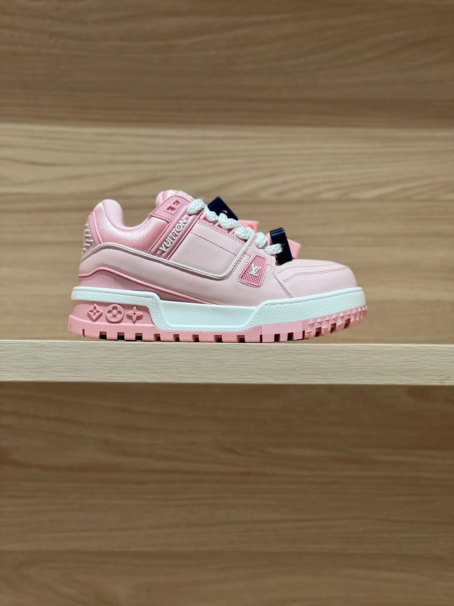 Pink low-top sneakers with white sole and light blue trim, lace-up design