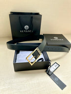 Navy leather belt with gold Greek key buckle and attached tag