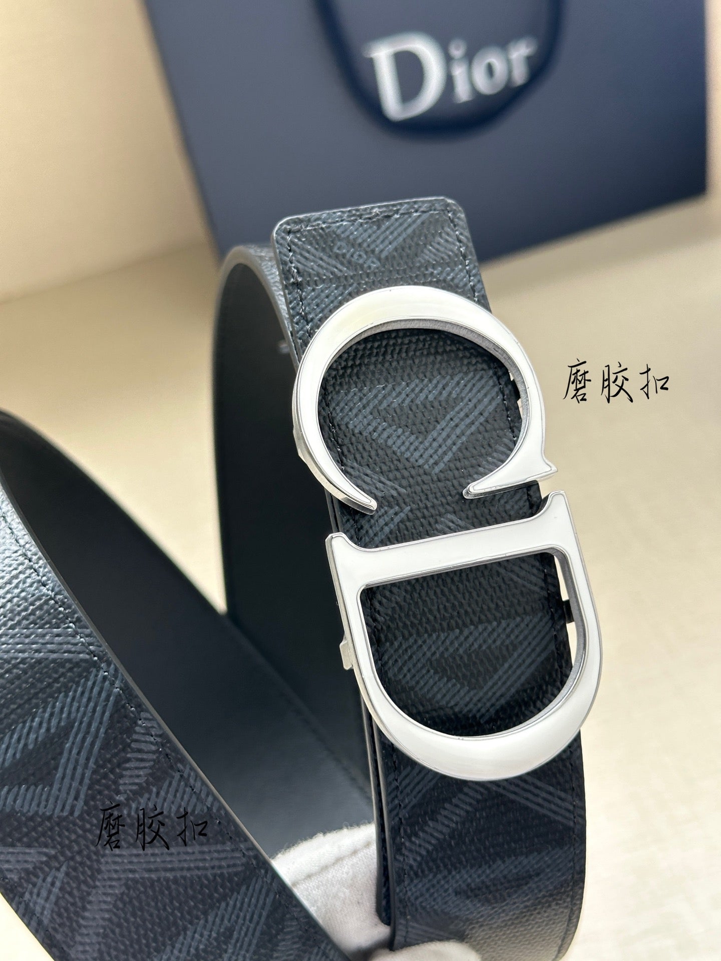 Dark blue Dior belt close-up of silver-tone CD buckle on textured strap