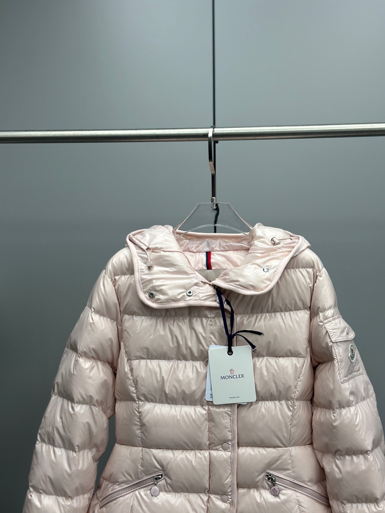 Moncler light pink hooded puffer jacket close-up of chest logo and zip
