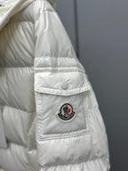White puffer jacket sleeve with circular patch, quilted panels, snap pocket flap