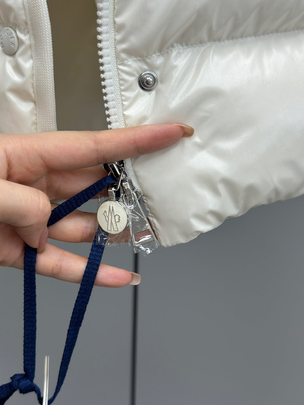 White puffer jacket drawstring pull with metal charm and snap button