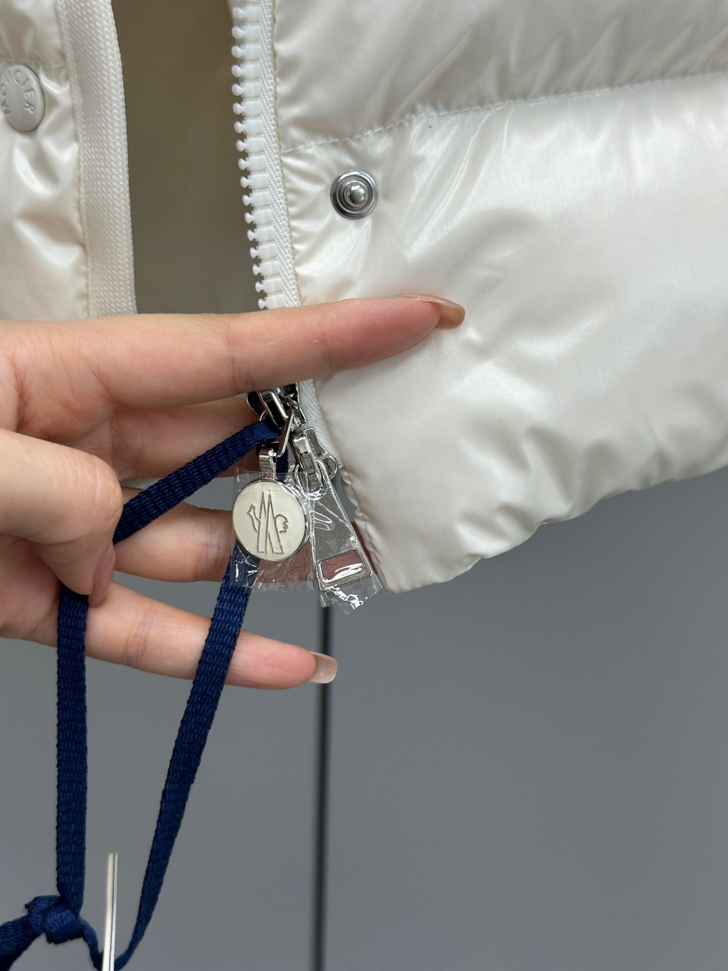 White puffer jacket drawstring pull with metal charm and snap button