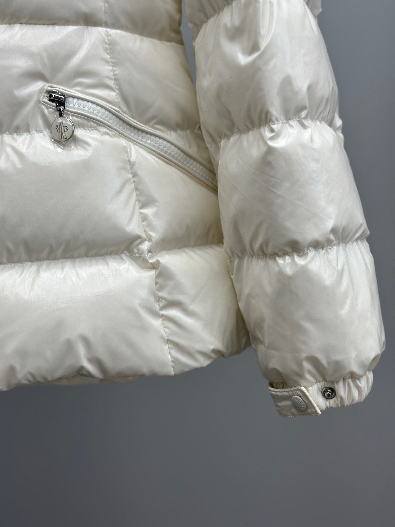 White quilted puffer jacket with diagonal zipper pocket, shiny fabric