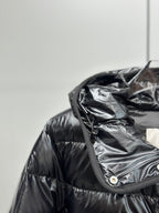 Hooded puffer jacket close-up with dark drawcord and snap button placket