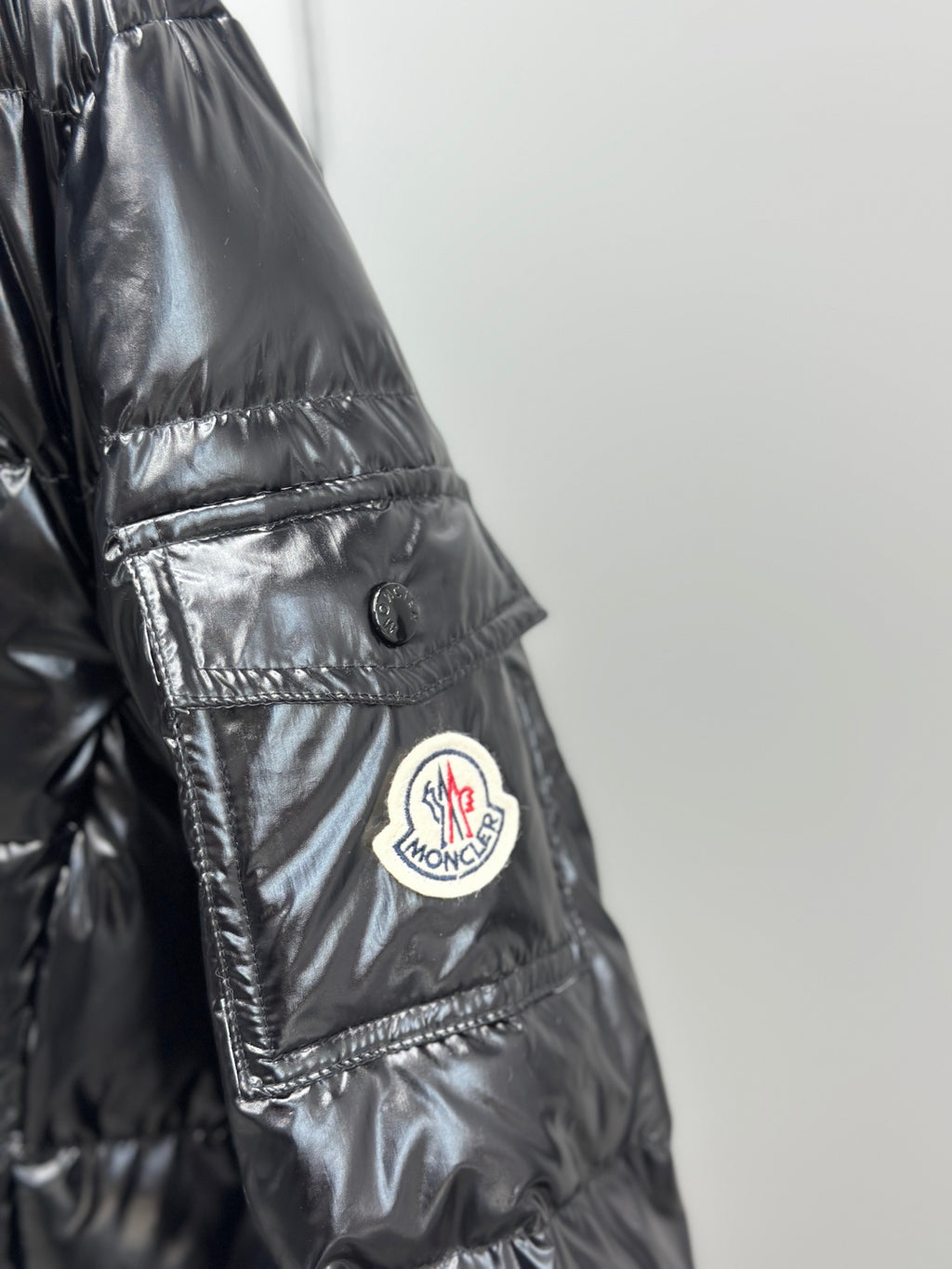 Moncler logo patch detail on glossy puffer jacket sleeve