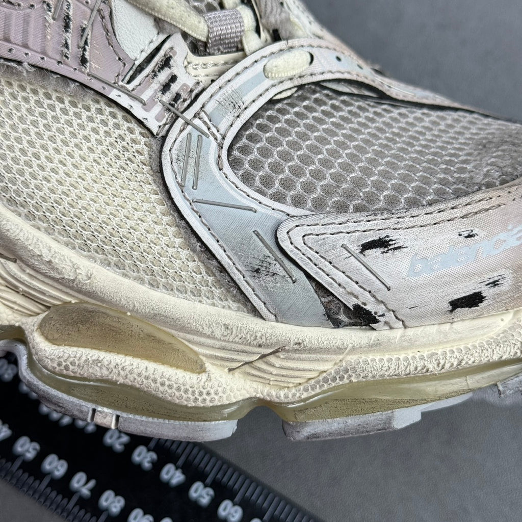Silver sneaker side panel with logo detail and textured sole