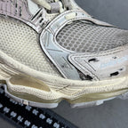 Silver sneaker side panel with logo detail and textured sole