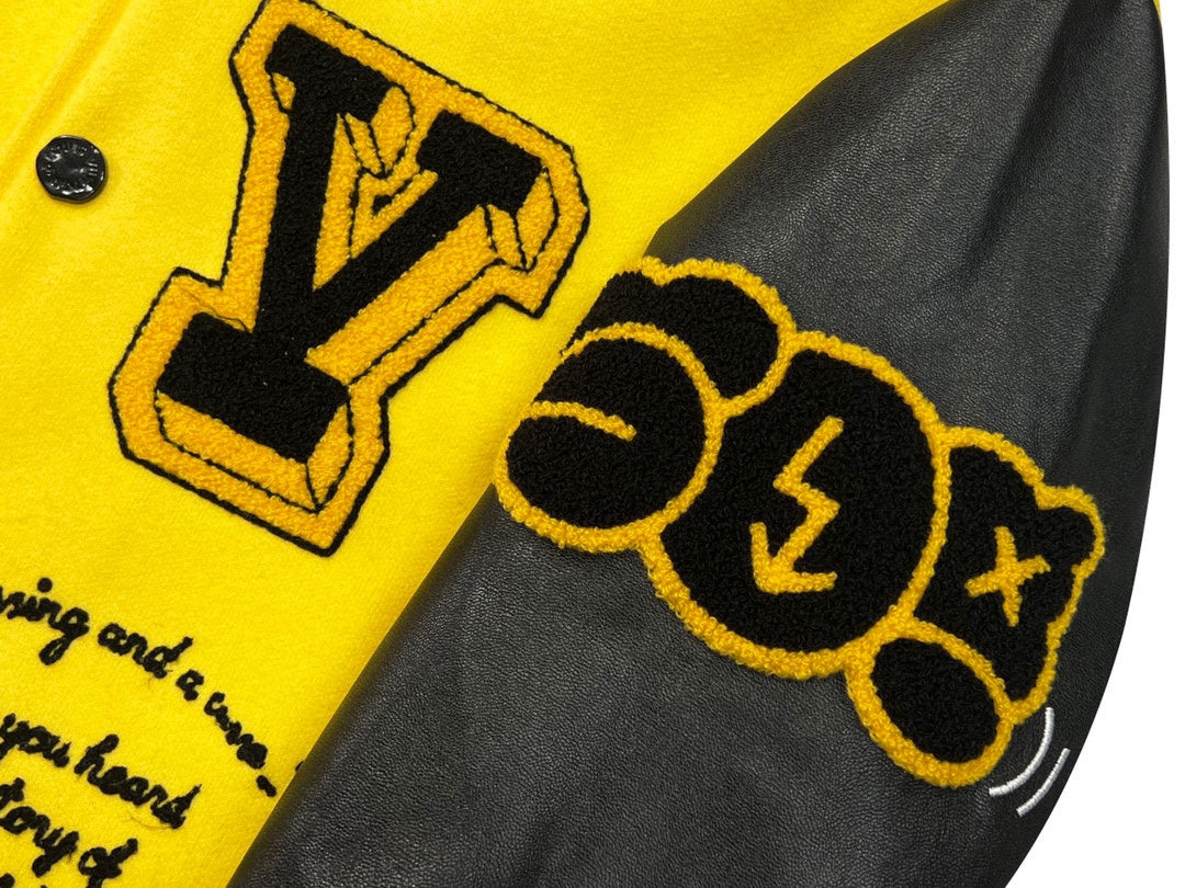 Yellow Louis Vuitton jacket sleeve and front seam with black emblem graphics on gray panels