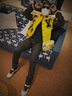 Louis Vuitton yellow varsity jacket with black accents, logo patches, and snap front
