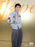 Light blue jacket with embroidered patches on sleeves and chest, ribbed cuffs