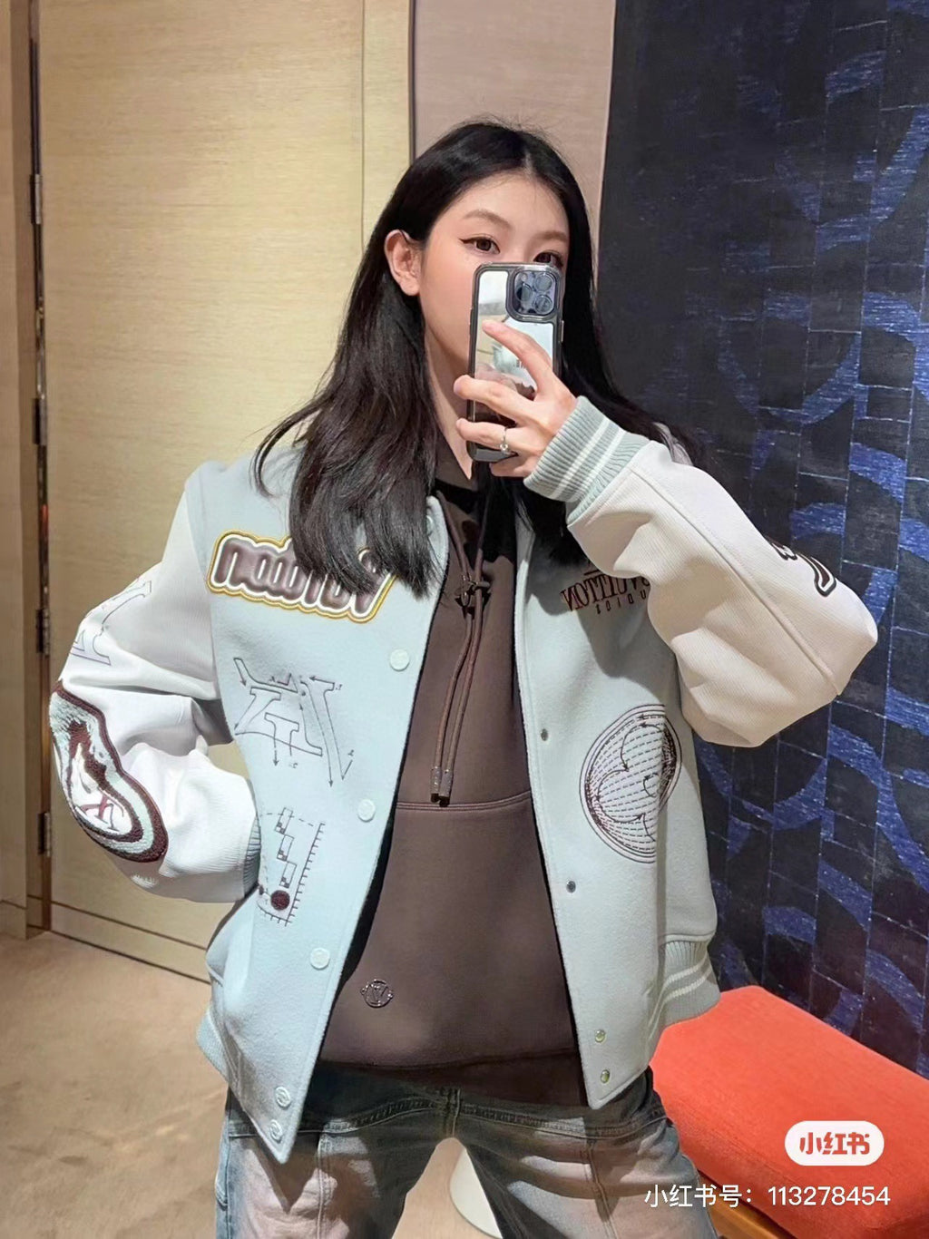 White Louis Vuitton-style jacket with graphic sleeve patches and ribbed cuffs