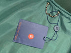 Louis Vuitton keychain with round charm and purple brand card on green garment