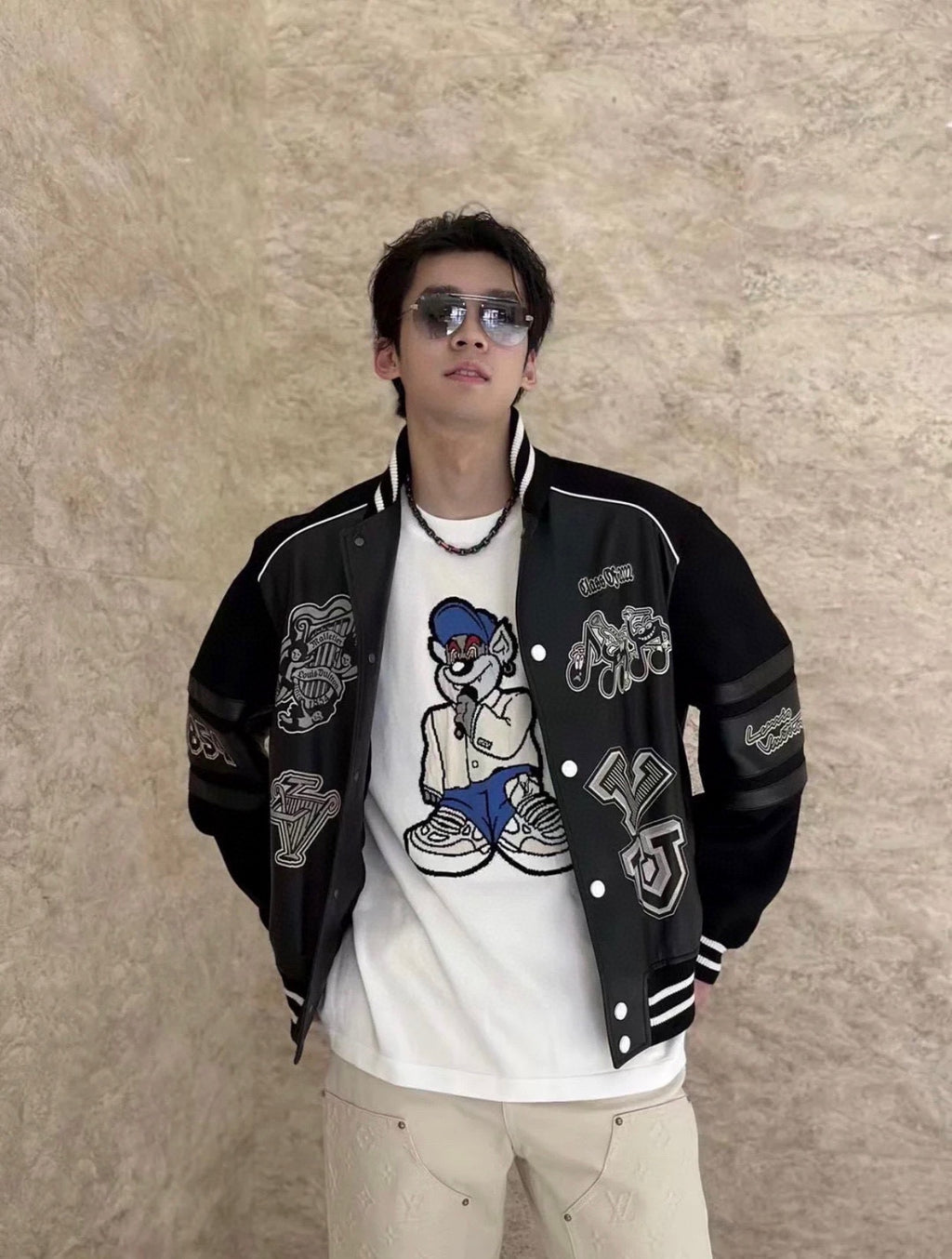 Louis Vuitton varsity jacket, black with white trim, snap front, and character-style patches