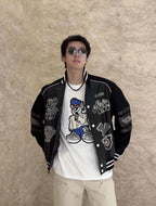 Louis Vuitton varsity jacket, black with white trim, snap front, and character-style patches