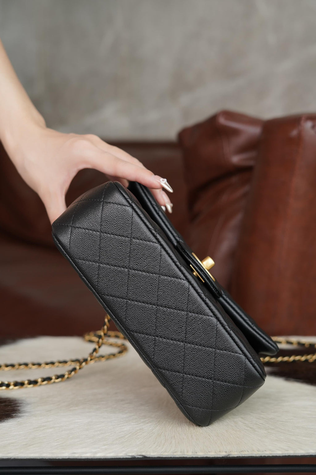 Chanel quilted black clutch-style handbag with gold zipper and chain