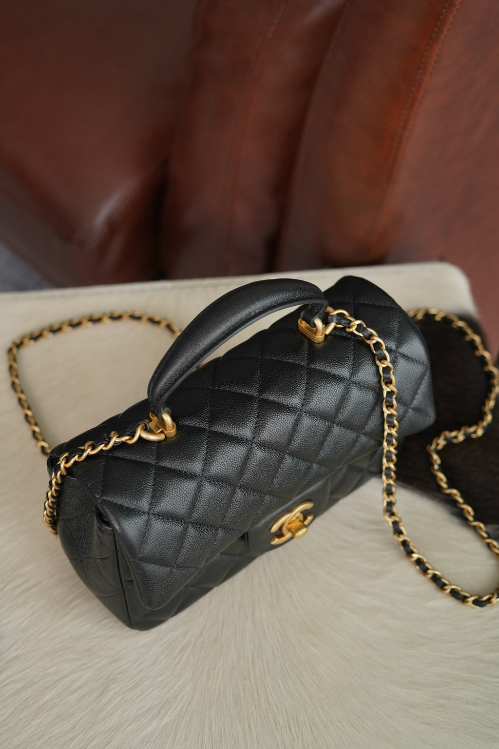 Chanel quilted black mini handbag with curved top handle and gold chain