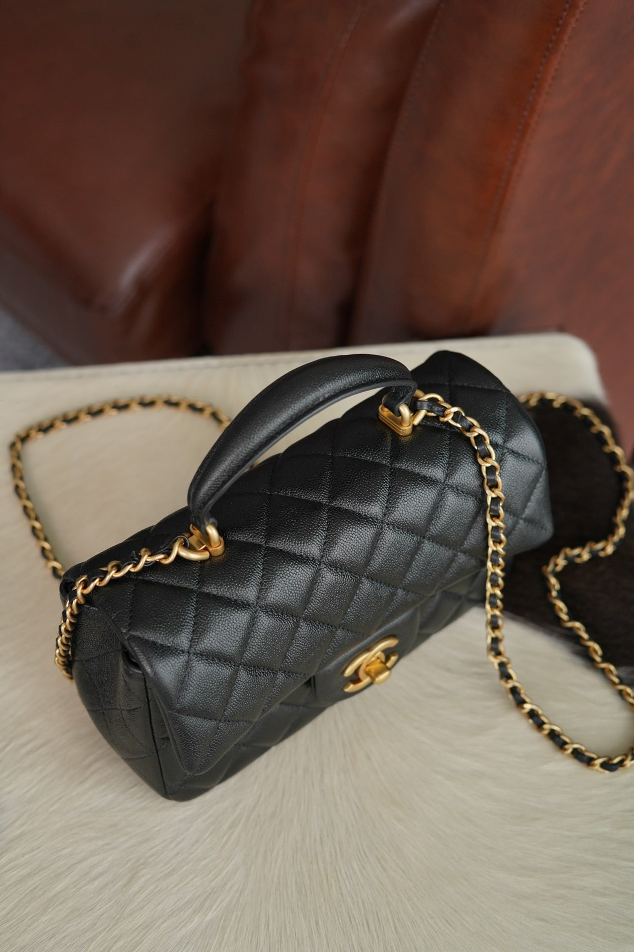 Chanel quilted black mini handbag with curved top handle and gold chain
