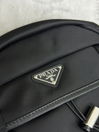 Prada logo patch on black nylon backpack flap with textured trim