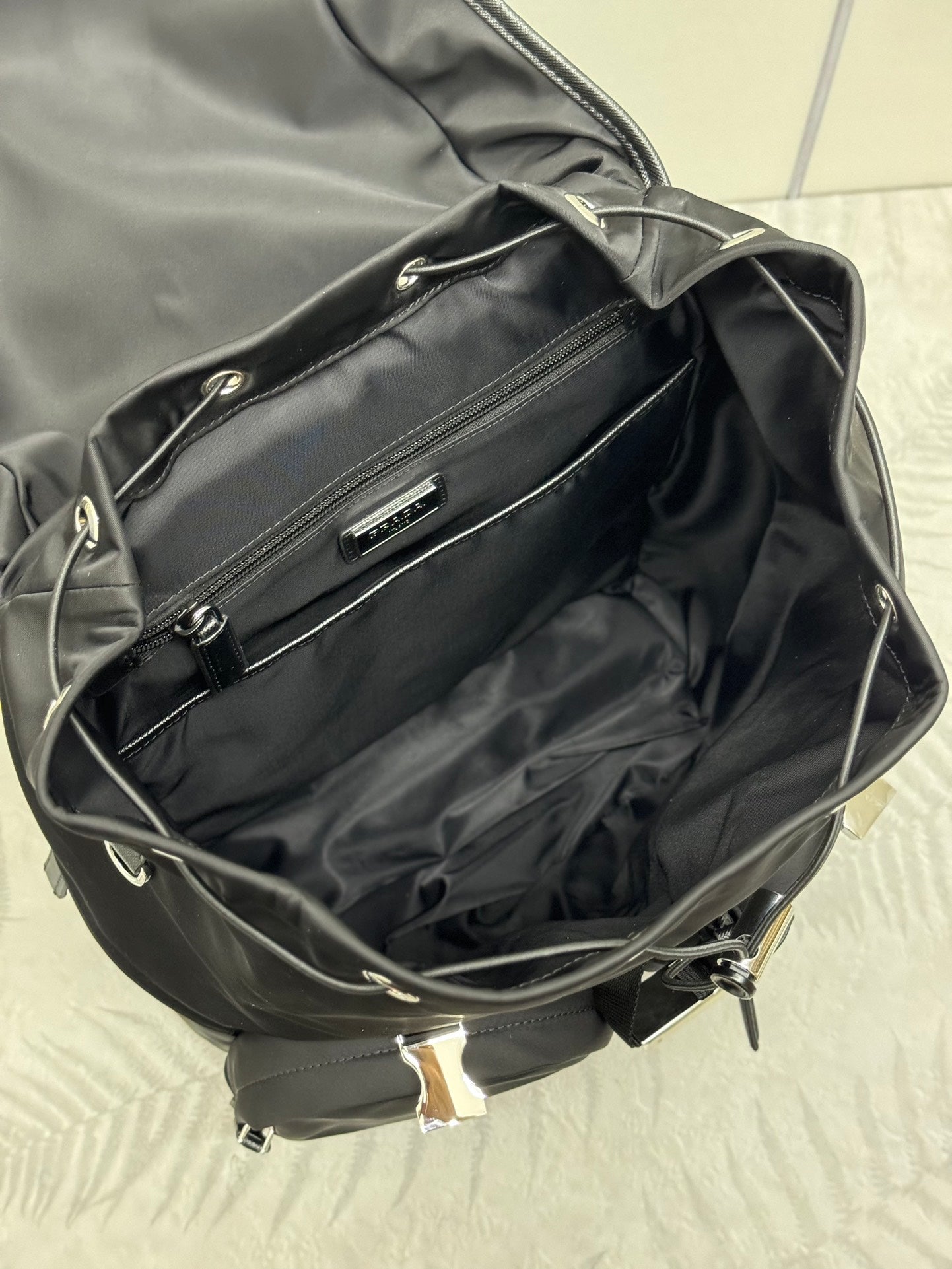 Prada black nylon tote-style bag open, showing interior lining and zipper