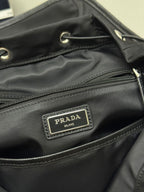 Prada Milano logo patch on black backpack front pocket with zipper