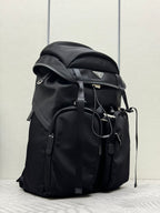 Prada black backpack with top flap, side pockets, and hanging strap details