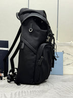 Prada black nylon backpack, side view with hanging cords and zip pocket