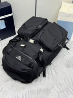 Prada black nylon backpack with top handle, buckles, and front pockets