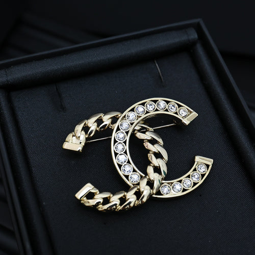 Gold-tone chain bracelet with interlocking C and clear rhinestone accents