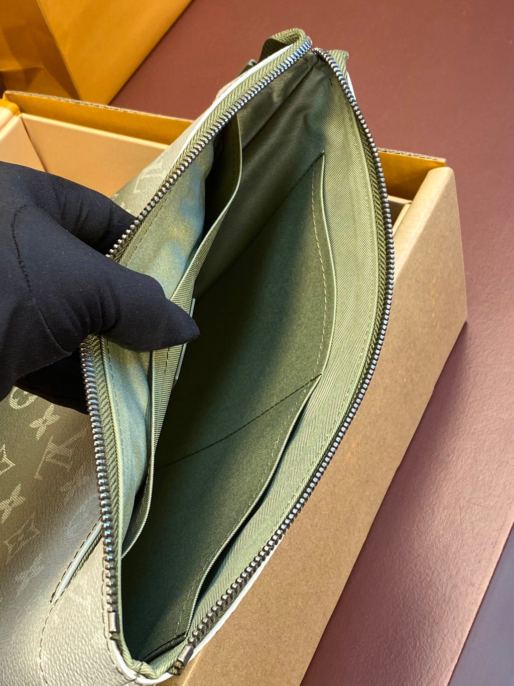 Louis Vuitton monogram wristlet bag open, teal lining and inner wall close-up