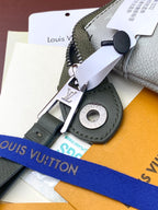 Louis Vuitton key holder accessory with silver clasp and black ring on card