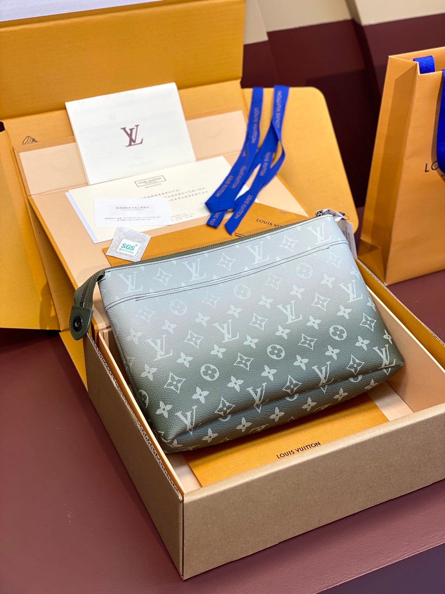 Small Louis Vuitton monogram clutch bag with green leather zipper pull, dark gray