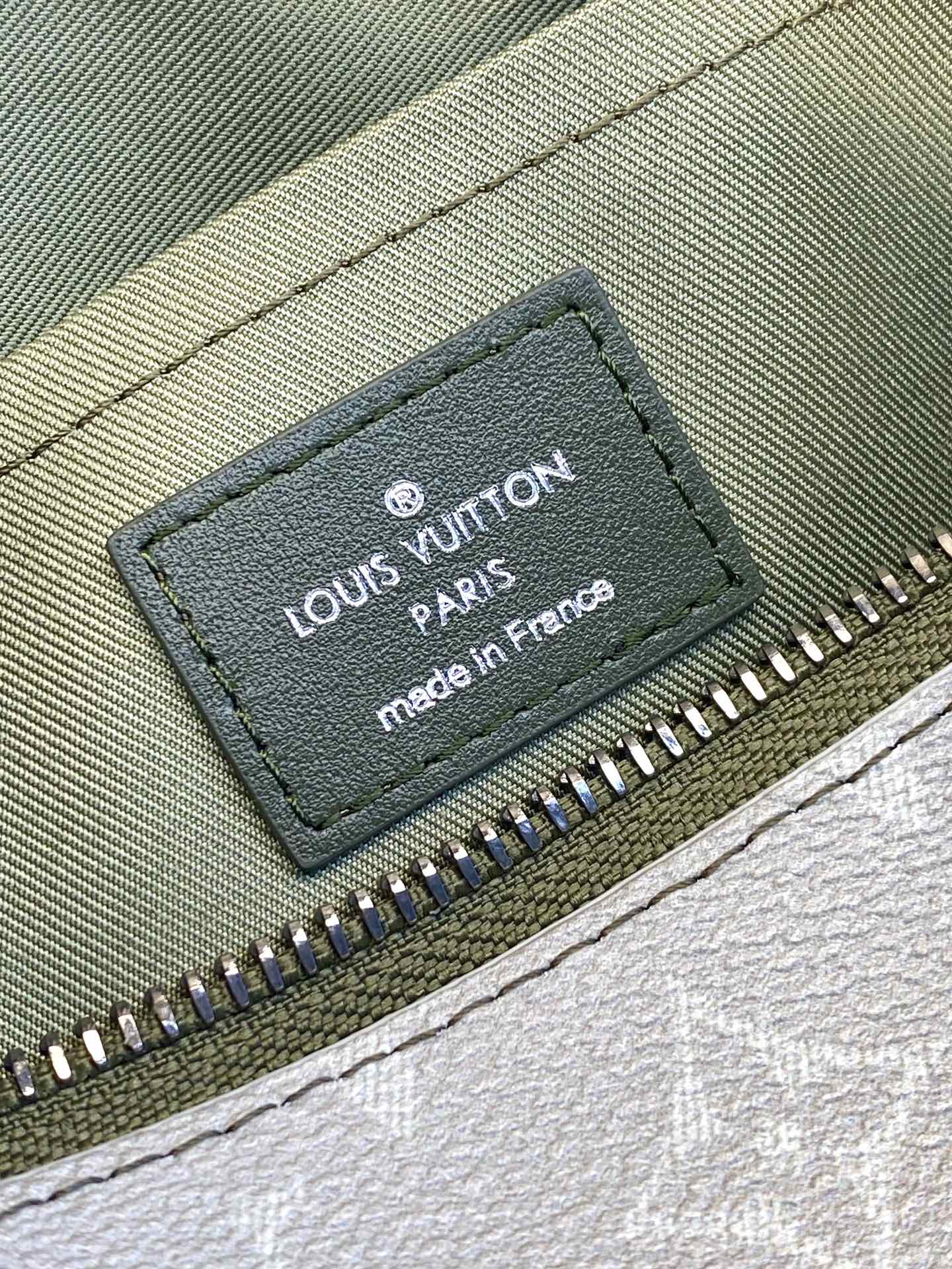 Louis Vuitton Paris label on dark olive lining inside zip pocket