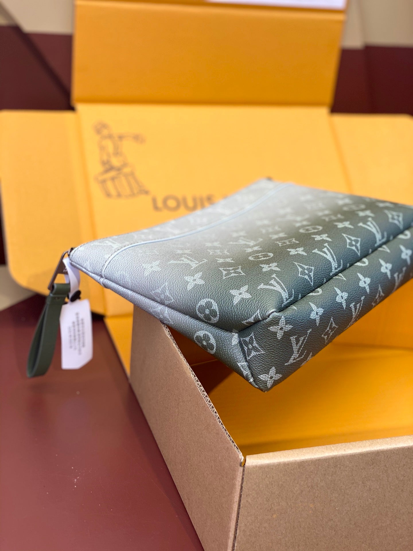 Louis Vuitton monogram wristlet bag, light blue-gray, side view with zipper