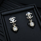 Chanel earrings with silver CC tops and black heart charms with clear crystal